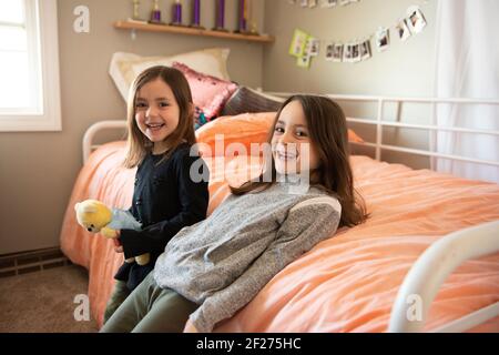 Zwei kleine Mädchen, die in ihrem Schlafzimmer lachen. Stockfoto