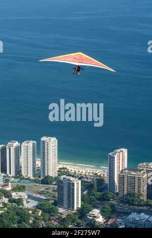 Wunderschöne Aussicht auf Hängegleiter fliegen über blauen Ozean und Gebäude Stockfoto