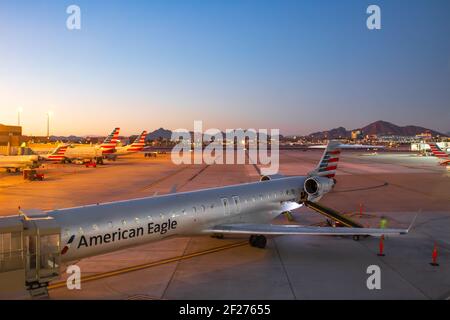 Sky Harbor Airport, Phoenix, Arizona, USA. Ein American Eagle, Mitsubishi CRJ-900ER Jet-Flugzeug wird am Abflugsteig direkt nach Sonnenuntergang geladen. Im Stockfoto