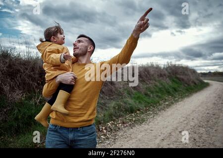 Ein Vater weist auf etwas zu seinem 2-jährigen Tochter in der Natur Stockfoto