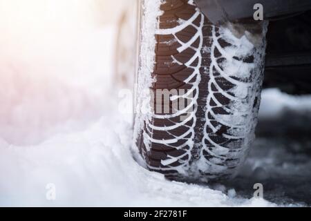 Autoreifen im Winter auf der schneebedeckten Straße, Nahaufnahme Stockfoto