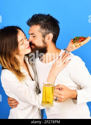 Schönes Paar Bier trinken und Pizza essen. Glückliche Familie Zeit. Mann und Frau essen Pizza. Liebevolles Paar küssen. Stockfoto