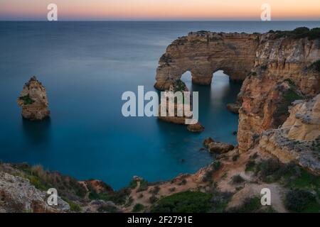 Natürliche Bogen Klippen von Praia da Marinha Strand bei Sonnenuntergang schöne Landschaft mit atlantik, in Lagoa Portugal Stockfoto