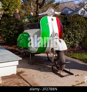 Clifton, VA, USA 11-14-2020: Ein Vespa Motorroller Motorrad in den gestreiften Farben der italienischen Flagge (grün, weiß und rot) von italienischen Piaggi gemalt Stockfoto