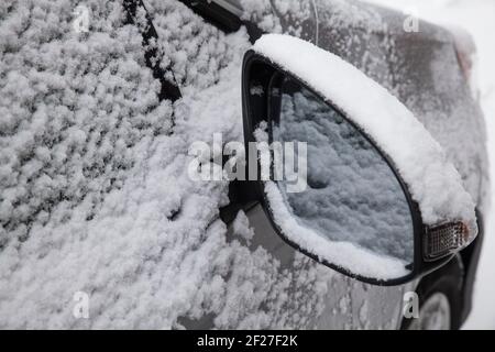 Der Rückspiegel des Autos war nach einem Sturm mit Schnee bedeckt Stockfoto