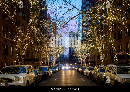 New York Street Night mit Weihnachtsbeleuchtung an Bäumen Mit seitlichem Parkplatz und Verkehr Stockfoto