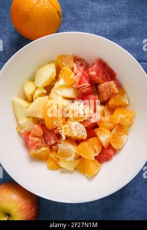 Draufsicht auf verschiedene Früchte in der weißen Schale Der Tisch zu Hause - Obstsalat gesunde Ernährung Konzept Vegane oder vegetarische Speisen verzehrfertig Stockfoto