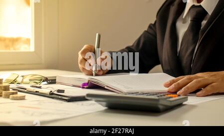 Business Männer dokumentieren Finanzen durch das Fenster und warme Sonnenlicht Finanzmanagement Ideen und Arbeitsunterlagen. Stockfoto