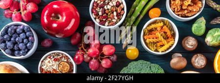 Veganes Food Variety Panorama. Obst und Gemüse, Hülsenfrüchte, Nudeln, Nüsse, Pilze. Gesunde Bio-Produkte, von oben geschossen Stockfoto