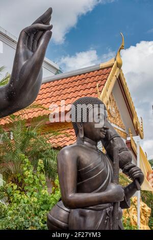 Die ausgestreckte Hand eines Leela Attitude Buddha über der Forest Monk Buddha Statue außerhalb des Thai Buddhist Temple, Wat Buddharangsi von Miami, Loca Stockfoto