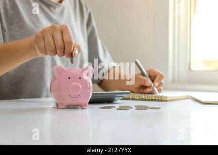 Geschäftsleute legen Münzen in ein Sparglas, einschließlich wachsenden Penny für Unternehmen, Finanz-und Buchhaltungs-Ideen. Stockfoto