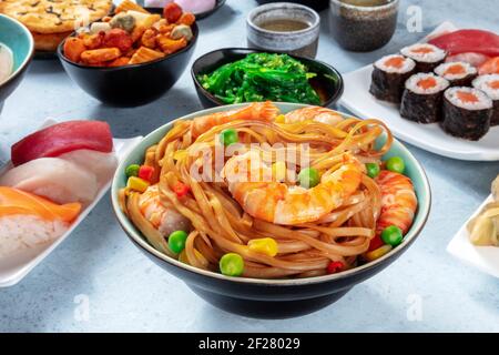 Japanisches Essen. Gebratene Nudeln mit Garnelen, Nigiri, Maki usw. umrühren Stockfoto