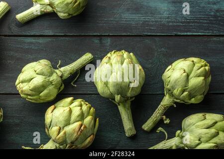 Viele Globenartischocken auf einem hölzernen Hintergrund, von oben geschossen Stockfoto