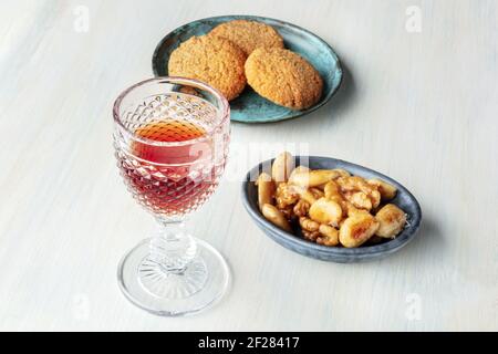 Ein Foto von einem Glas süßen Wein mit Keksen Und Muttern Stockfoto