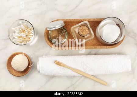 Nachhaltige Toilettenartikel, von oben geschossen. Hausgemachte Lotionen, Wattepads, Bambuszahnbürste, natürlicher Konjac-Schwamm, biologische Abbauprodukte Stockfoto