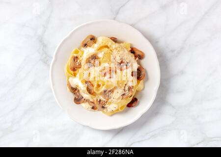 Pappardelle mit Pilzen, Sahnesauce und geriebenem Parmesankäse Stockfoto