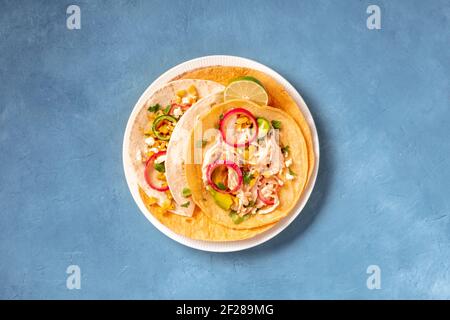 Mexikanische Tacos, Tortillas mit gezupftem Hühnerfleisch und Avocado Stockfoto