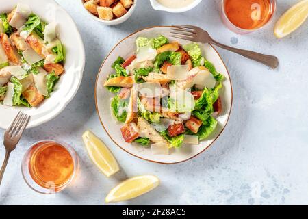 Chicken Caesar Salat, von oben mit Zitronen und Wein geschossen Stockfoto