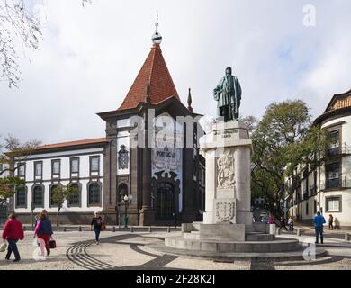 Statue des Navigators JoÃ£o GonÃ§alves Zarco in Funchal, Madeira mit der Bank von Portugal im Hintergrund Stockfoto