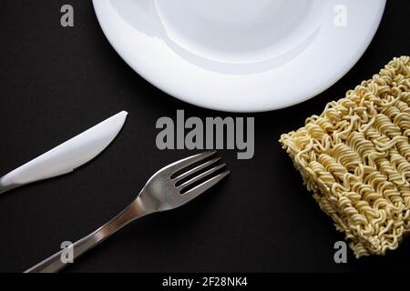 Nudeln auf einem Teller. Vermicelli in Form eines Quadrats auf einem runden Teller. Stockfoto