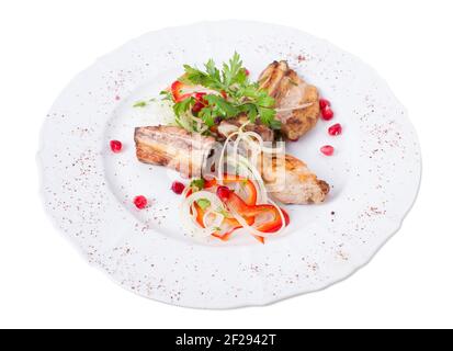 Gegrillte Lammkarree im östlichen Stil mit frischem Gemüse und Granatapfelkernen. Isoliert auf weißem Hintergrund. Stockfoto