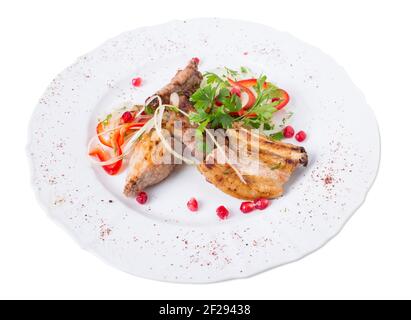 Gegrillte Lammkarree im östlichen Stil mit frischem Gemüse und Granatapfelkernen. Isoliert auf weißem Hintergrund. Stockfoto