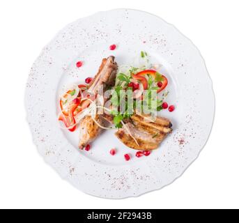 Gegrillte Lammkarree im östlichen Stil mit frischem Gemüse und Granatapfelkernen. Isoliert auf weißem Hintergrund. Stockfoto