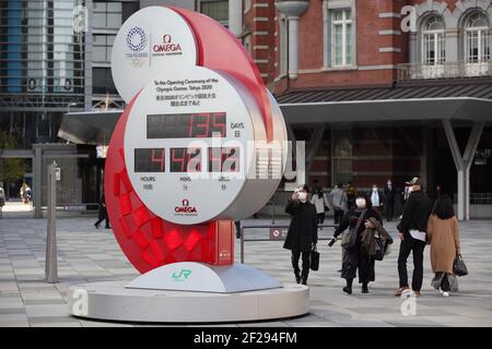 Tokio, Japan. März 2021, 10th. Ein Fußgänger, der eine Gesichtsmaske trägt, um die Verbreitung von Covid-19 zu verhindern, fotografiert die Countdown-Uhr der Olympischen Spiele 2020 in Tokio, die 135 Tage bis zur offiziellen Eröffnung des Sportereignisses anzeigt. Kredit: SOPA Images Limited/Alamy Live Nachrichten Stockfoto