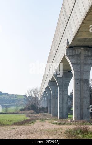 Tiefere Ansicht eines modernen Aquädukts mit seinen Betonsäulen. Tiefbauarbeiten. Wasserverkehrsinfrastruktur Stockfoto