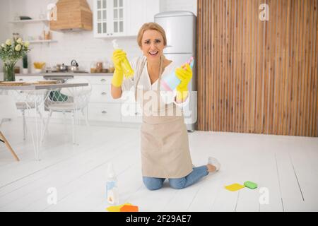 Hausfrau in Schürze und Handschuhe sah genervt Stockfoto