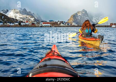 Kajakfahren in reine, Moskenes, Moskenesøya Island, Lofoten Islands, Norwegen. Landschaft mit dem Berg Olstinden. Stockfoto