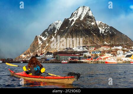 Kajakfahren in reine, Moskenes, Moskenesøya Island, Lofoten Islands, Norwegen. Landschaft mit dem Berg Olstinden. Stockfoto