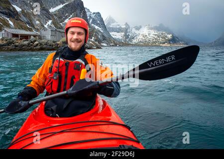 Kajakfahren in reine, Moskenes, Moskenesøya Island, Lofoten Islands, Norwegen. Landschaft mit dem Berg Olstinden. Stockfoto