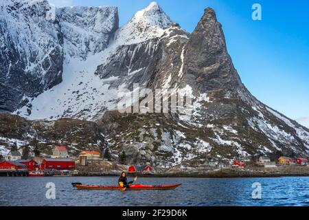 Kajakfahren in reine, Moskenes, Moskenesøya Island, Lofoten Islands, Norwegen. Landschaft mit dem Berg Olstinden. Stockfoto