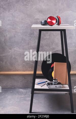Modernes oder Retro-Vintage-Konzept bei Hocker in der Nähe graue Wand Hintergrundstruktur. Lebensstilvolles Musikdesign im Regal Stockfoto