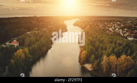 Sonnenuntergang über der Flussantenne. Niemand Natur Landschaft. Hütten in der Stadtlandschaft Straße. Städtisches Gebäude am Ufer. Urlaub in den Vororten. Natürliche Schönheit. Laubwald im Herbst. Licht bei Sonnenuntergang. Ontario, Kanada, Amerika Stockfoto