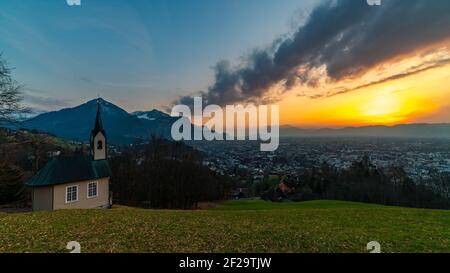 Schöner Sonnenuntergang und Nachglühen in Dornbirn mit Wolken, die auf die Rhomberkapelle zeigen, farbiger Himmel über Rheintal, Staufenspitze, Säntis Stockfoto