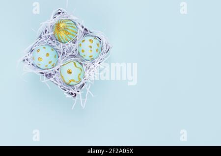 Osterhintergrund - blaue Eier mit goldenen Punkten in Box auf blauem Hintergrund, Draufsicht. Stockfoto