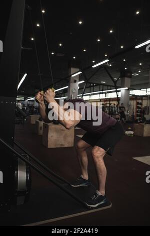 Männlicher Athlet beim Training auf dem Skigerät in der Cross-Fit-Turnhalle Stockfoto