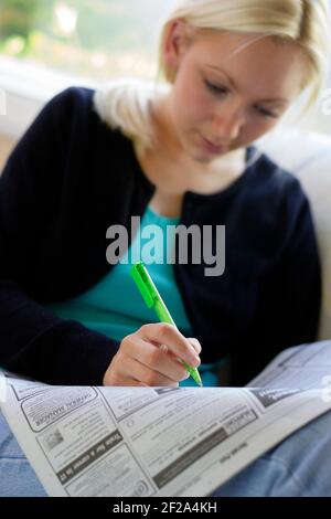 Mädchen, die durch die lokale Zeitung Stockfoto