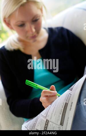 Mädchen, die durch die lokale Zeitung Stockfoto