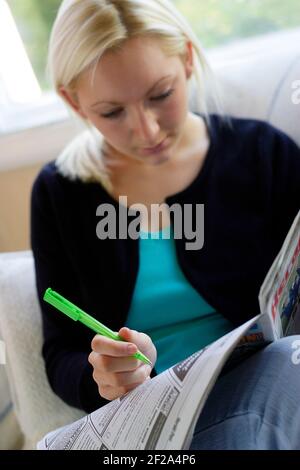 Mädchen, die durch die lokale Zeitung Stockfoto