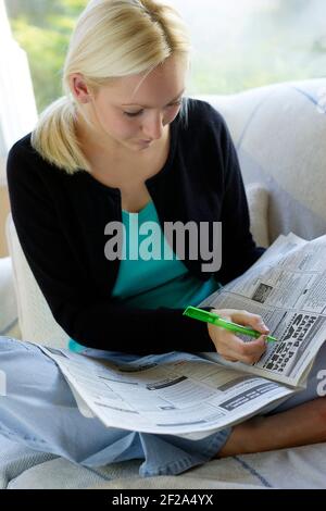 Mädchen, die durch die lokale Zeitung Stockfoto