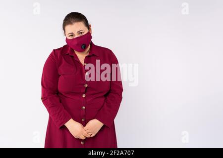 Müde, traurig übergewichtige Frau trägt Maske isoliert auf weißem Hintergrund mit Werbefläche. Pandemie. Bekämpfung des Virus. Stockfoto