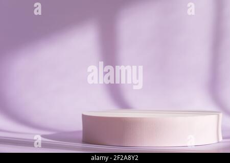 Lila Hintergrund mit rosa runden Podium, Display, Mockup. Kosmetische Produktpräsentation mit Schatten und Licht aus Fenstern. Natürlicher Schatten des Fensters Stockfoto