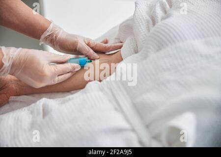 Ärztin, die Injektion in Patientenarm macht Stockfoto