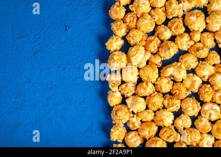 Popcorn auf blauem Hintergrund. Blick von oben Stockfoto