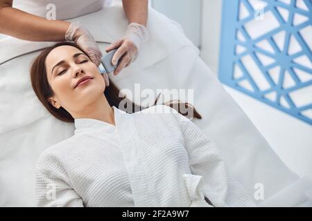 Attraktive Frau, die Gesichtsbehandlung im Wellness-Center Stockfoto