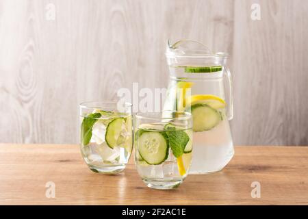 Wasser oder Wasser mit Gurke und Zitrone auf Holz Tabelle Stockfoto