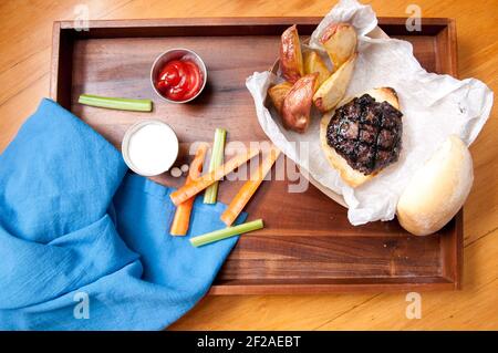 Ethisch angehobener Schweinefleischburger mit handgeschnittenen roten Kartoffelkeilen Und Gemüsestöcke nehmen Stock Foto Stockfoto